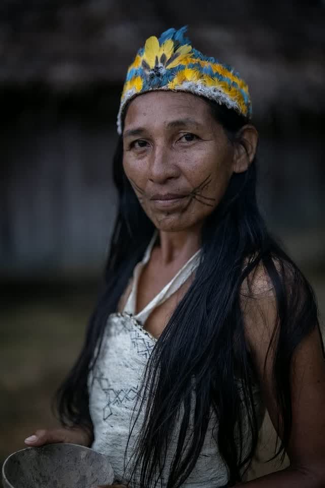 Mujer Tikuna con corona de plumas